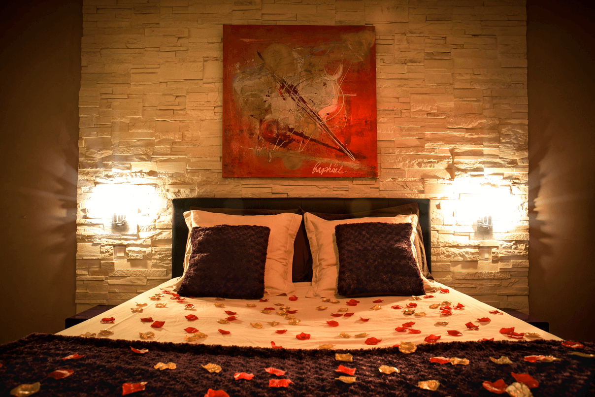 Grand lit confortable avec pétale de rose dans la Suite Romantique et spa votre appartement tous confort en Location privée APPART SPA 21 de Dijon votre appartement privé de luxe, spa et sauna